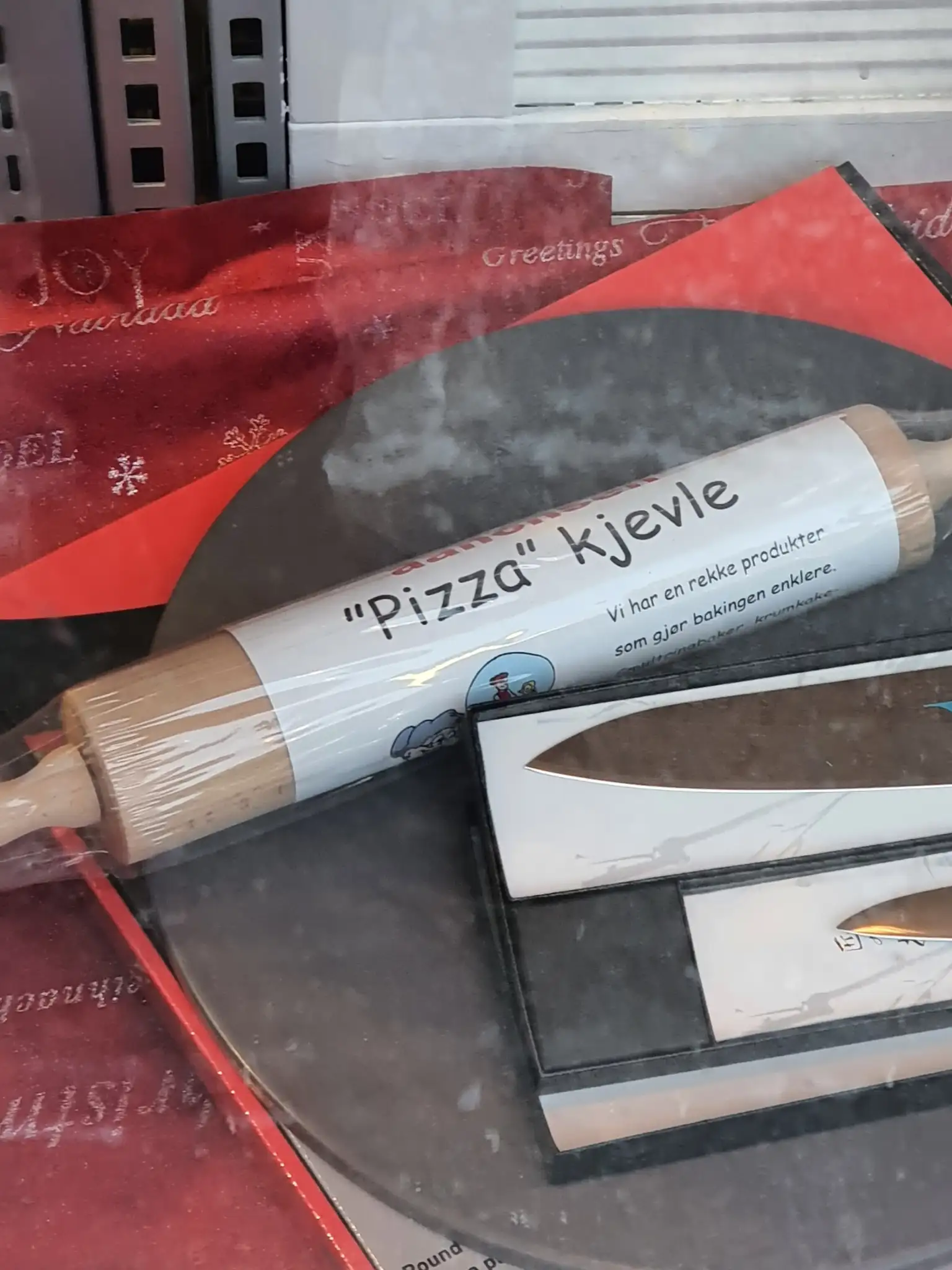 Produktbilde av en pizzakjevle. På kjevlen er en etikett, der ordet pizza er skrevet i hermetegn.